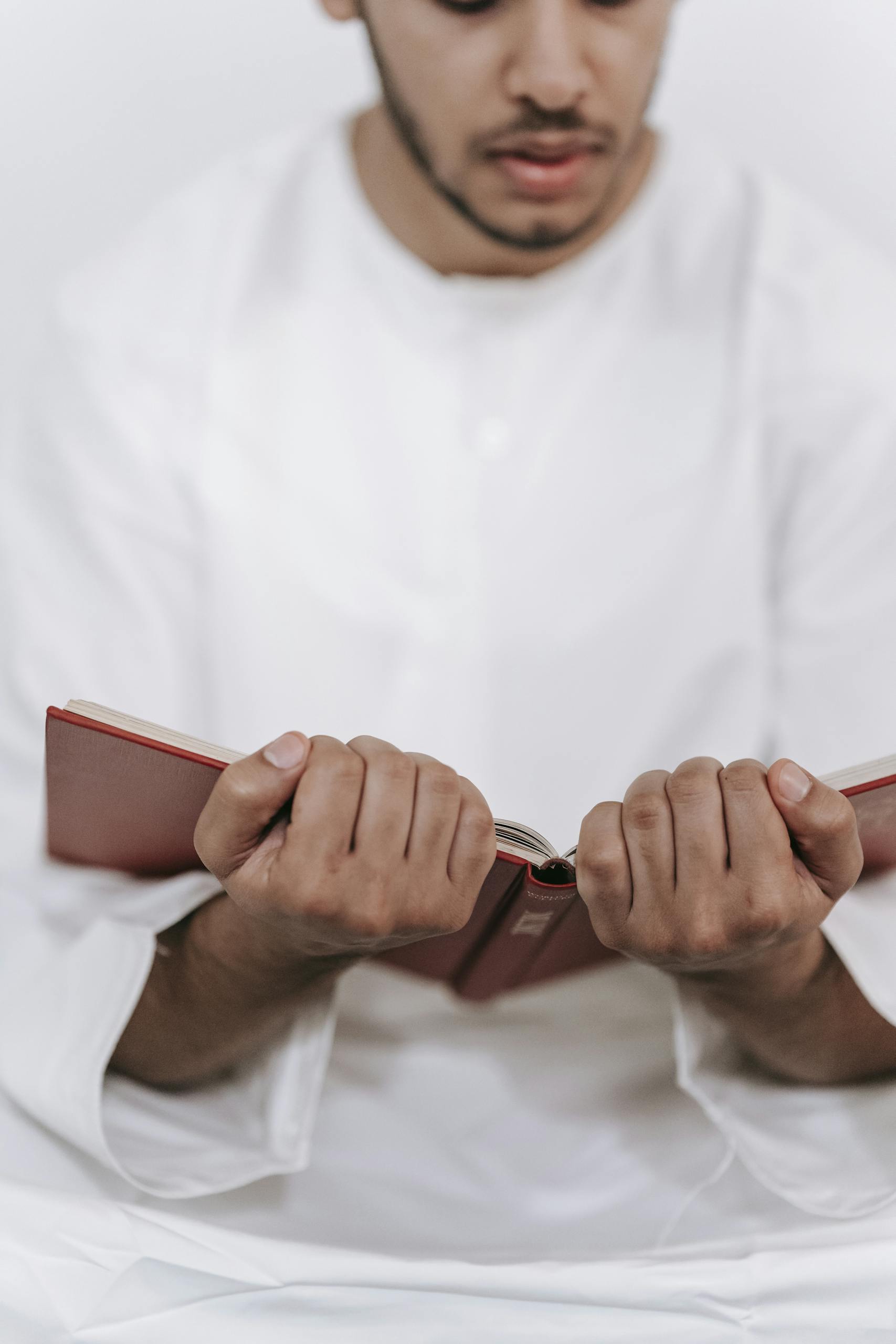 Close-up of a man reading a religious book, focusing on spirituality and tradition.